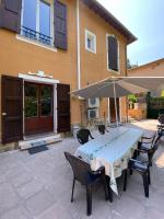 einen Tisch mit einem Sonnenschirm auf einer Terrasse in der Unterkunft Villa Serenice - F2 au calme, climatisé, WIFI et parking gratuit in Nizza