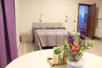 Una habitación con una mesa con un jarrón con flores. en Hotel Ristorante La Collina, en Imola