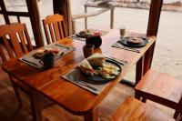un tavolo in legno con due piatti di cibo sopra di Ecoaldea Tanaj Hotel Boutique a Conhuas