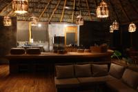 una stanza con un bar con un divano e lampadari di Ecoaldea Tanaj Hotel Boutique a Conhuas