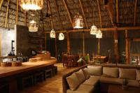 un soggiorno con divano, tavoli e lampadari a braccio di Ecoaldea Tanaj Hotel Boutique a Conhuas