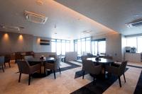 a dining room with tables and chairs and windows at THE RISE Osaka Universal Bayside in Osaka