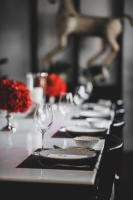 a long table with plates and a wine glass at Siri Villa Chiang Mai in Chiang Mai