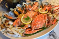 een bord met vis op een tafel bij Madusea Grand Villa มาดูซี แกรนด์ วิลล่า in Ko Larn