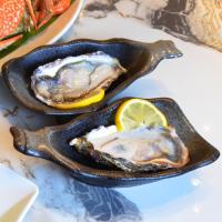 twee oesters in een gietijzeren koekenpan met een citroen bij Madusea Grand Villa มาดูซี แกรนด์ วิลล่า in Ko Larn