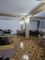 Pensiunea Anisoara في Chişcău: غرفة بطاولات وكراسي في غرفة ذات سقف