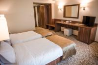a hotel room with two beds and a desk at Hotel Arnia in Iaşi