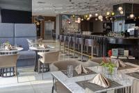 a restaurant with tables and chairs and a bar at Novotel Hotel Residences at Acqua- AMOREsuite in Manila