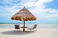 two chairs and an umbrella on the beach at Nice Sea Resort in Srithanu