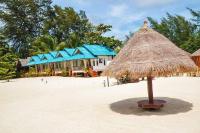 a building with a straw umbrella on the beach at Nice Sea Resort in Srithanu