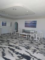 a room with white tables and chairs and a couch at Korali Garden in Naxos Chora