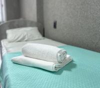 Una toalla está sentada encima de una cama. en Silk Way, en Semey