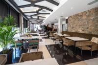 Un restaurante con mesas y sillas y una pared de piedra. en Hotel President & SPA Maglaj, en Maglaj