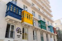 Un edificio con ventanas de colores en los laterales. en Alavits Hotel by ST Hotels, en Il-Gżira
