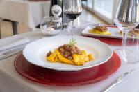 ヴェントゥリーナにあるTerme Di Venturina - Toscanaのテーブルの上に置かれたワイングラスの置かれた料理の皿