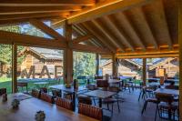Un comedor con mesas y sillas y ventanas. en MAD Retreat Hotel, en Nendaz