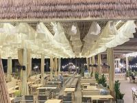 a restaurant with tables and chairs under a ceiling at Villa 4 phòng ngủ NovaWorld Phan Thiết in Bình Tú