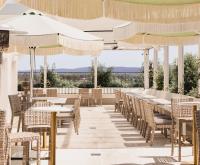 Un restaurante con mesas, sillas y sombrillas. en Astina Suites, Penrith, en Penrith