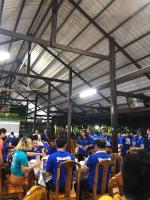a group of people in blue shirts sitting at tables at Điểm Du Lịch Sinh Thái Cộng Đồng Bình Minh in Xóm Cái Xếp