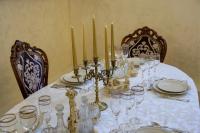 una mesa con un mantel blanco y velas en ella en Hotel Boutique ANEMONA, en Craiova