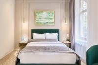 Un dormitorio con una cama grande con cabecero verde. en Maestro Address Baku Hotel, en Baku