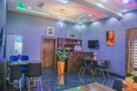 a bar in a restaurant with a person standing at the counter at The Clifford Apartment Owerri in Owerri