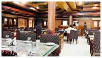 un comedor con mesas y personas de fondo en Power Onn Grand Cuttack Residency, en Cuttack