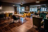 een restaurant met houten vloeren en tafels en stoelen bij Queens Head in Leyburn