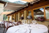 a group of tables and chairs with wine glasses at Residenza Del Sole in Gressoney-Saint-Jean