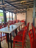 een rij tafels en rode stoelen in een restaurant bij Vila OK2 in Costinesti