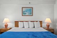 ein Schlafzimmer mit einem blauen und weißen Bett mit zwei Lampen in der Unterkunft Beachcomber Motel in Ocean City