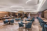 Un restaurante con mesas y sillas y un bar. en Crystal Hotel Guangzhou Huadu, en Huadu