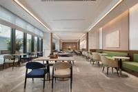 Hilton Garden Inn Chengdu Jinniu Yipintianxia في تشنغدو: مطعم به طاولات وكراسي ونوافذ