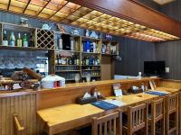 eine Bar mit einem langen Holztisch und Stühlen in der Unterkunft モンゴリアンテーマパークジャパン in Kamigō