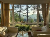 ein Wohnzimmer mit einem großen Fenster mit Aussicht in der Unterkunft Lan Anh Villas Resort in Da Lat