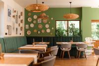 een restaurant met groene muren en houten tafels en stoelen bij Pensiunea Bucuria Cheia & Ferma Animale in Cheia