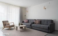 ein Wohnzimmer mit einer Couch und einem Tisch und einem Stuhl in der Unterkunft Luxury Apartments And Studios At Sea Side By Rently in Eilat