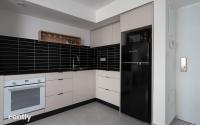 eine Küche mit weißen Schränken und einem schwarzen Kühlschrank in der Unterkunft Luxury Apartments And Studios At Sea Side By Rently in Eilat