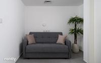 einen grauen Stuhl in einem Raum mit Topfpflanze in der Unterkunft Luxury Apartments And Studios At Sea Side By Rently in Eilat