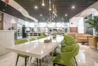 a restaurant with a white table and green chairs at Star Hotel in Baoding