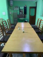 una gran mesa de madera en una habitación con sillas en Hotel Indra, en Srinagar