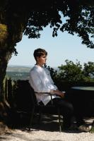 サンセールにあるLes Hauts de Sancerreの木の下の椅子に座っている男性