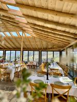 een eetkamer met tafels en stoelen en een houten plafond bij Mimani Stone House Roshnik in Roshnik