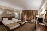 a hotel room with two beds and a television at Hotel Arnia in Iaşi