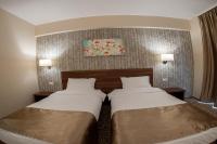 a hotel room with two beds and a painting on the wall at Hotel Arnia in Iaşi