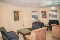 uma sala de espera com cadeiras e uma mesa em Clemstar Hotel em Benin City