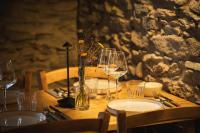 Una mesa de madera con platos y copas de vino encima. en Rifugio Pra La Peira, en Riclaretto