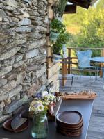 un patio con una mesa y una pared de piedra en Rifugio Pra La Peira, en Riclaretto