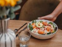 ベルサイユにあるHôtel le Bout du Parc de Versaillesのテーブルの上にはサラダのボウルと水の入ったグラスが置かれている