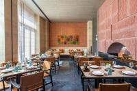 Narat新疆华美胜地那拉提英迪格酒店的有桌椅和壁炉的餐厅